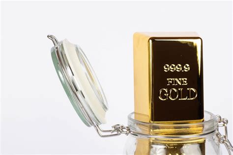 Close up of a gold bar in a glass jar on a white background - Creative Commons Bilder