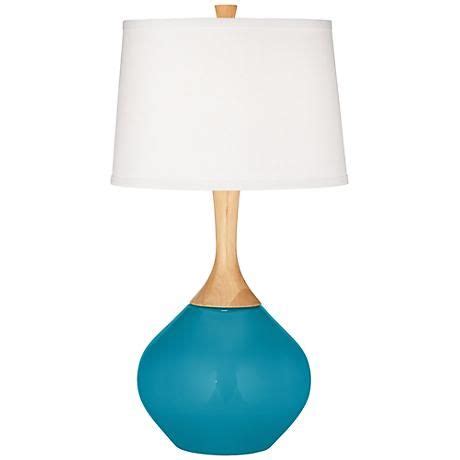 A designer Caribbean Blue Sea color table lamp with elegant wood accents and a plain white ...