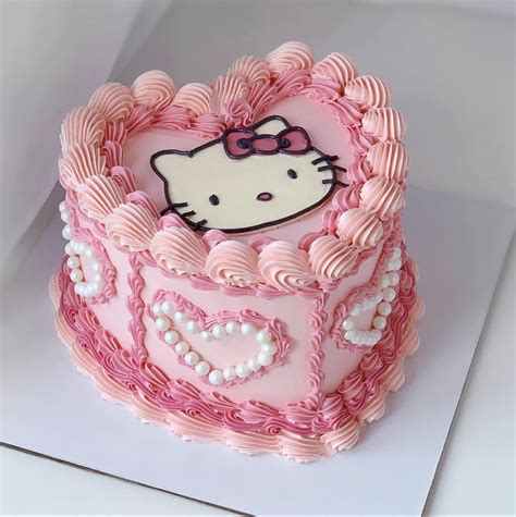 a hello kitty birthday cake with pink icing and pearls on the bottom is shown