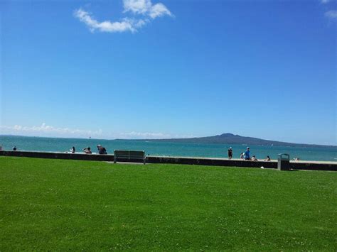 people are sitting on benches near the water and looking out at the ...