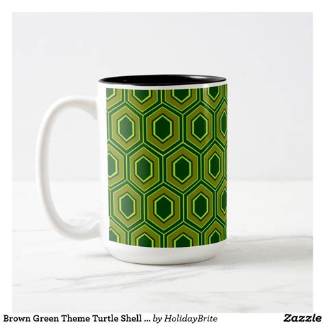a green and black coffee mug on a white table with the words brown ...