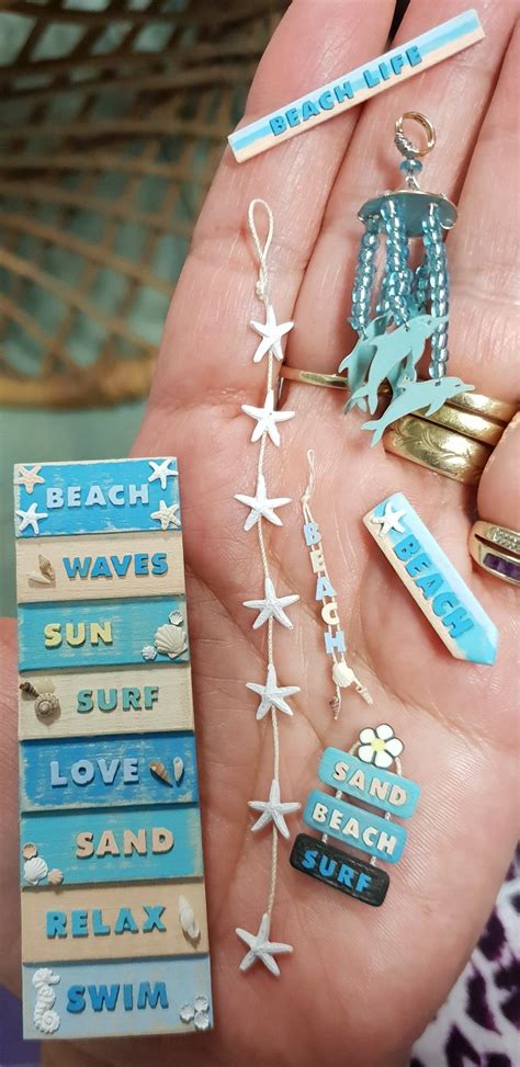 someone is holding some beach themed items in their hand, including pins and magnets