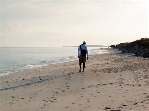 Man Walking on a Black Beach · Free Stock Photo