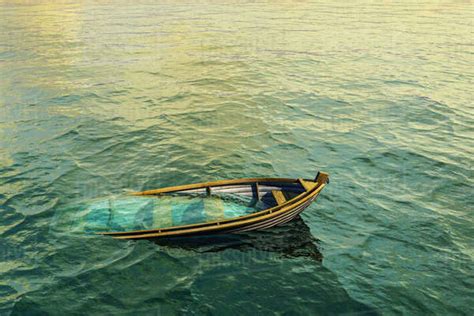 Abandoned sinking rowboat in ocean - Stock Photo - Dissolve