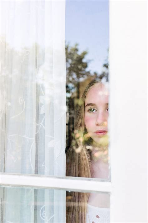 «Teenage Girl At A Window With Reflections Of Outdoor Garden» del colaborador de Stocksy «Angela ...