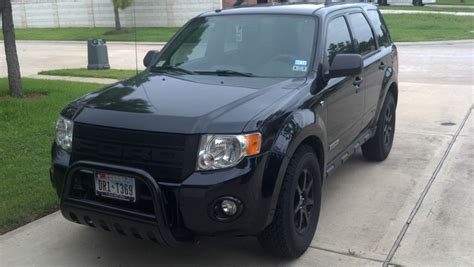 a black suv is parked on the sidewalk