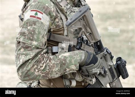 Soldier with assault rifle and flag of Lebanon on military uniform ...