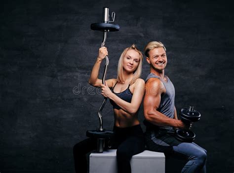 Studio Portrait Of Attractive Fitness Couple Sit On A Wooden Box Stock ...