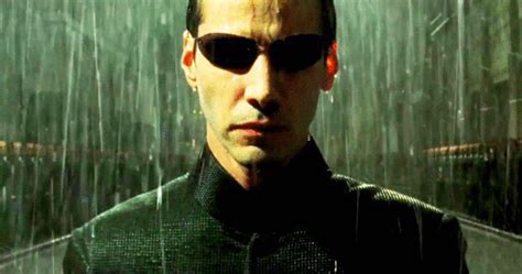 a man wearing sunglasses standing in the rain