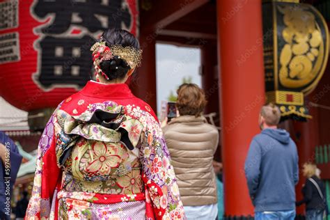 Young girl wearing Japanese kimono standing in front of Sensoji Temple ...