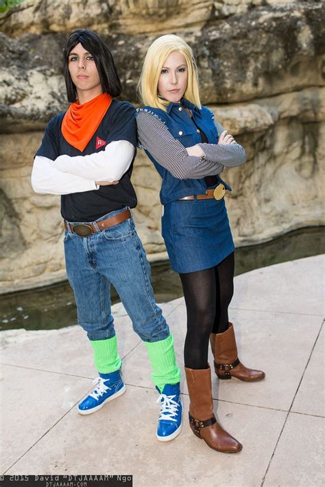 two people standing next to each other in front of a rock wall and ...