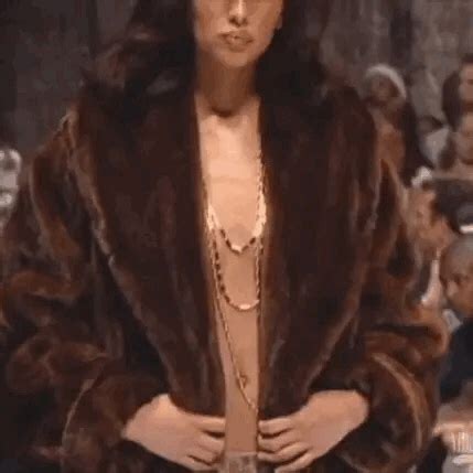 a woman in a fur coat standing next to a crowd
