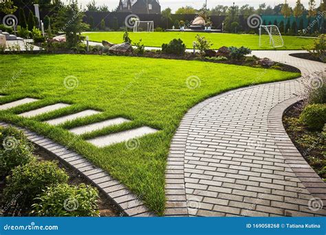 Landscaping of the Garden. Path Curving through Lawn with Green Grass and Walkway Tiles. Stock ...