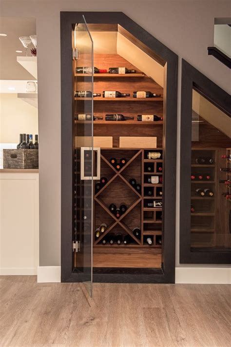 A small yet stylish wine cellar under the stairs with various plywood shelves for the bottles ...