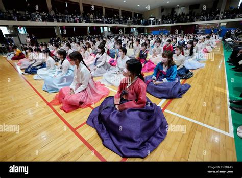 High school seniors clad in traditional attire attend a joint graduation and coming-of-age ...