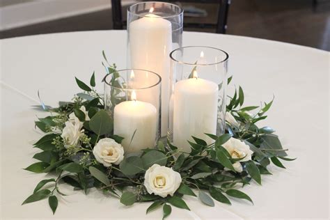 Greenery and spray rose centerpiece with pillar candles //Celebration ...
