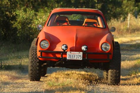 an orange car is parked in the grass