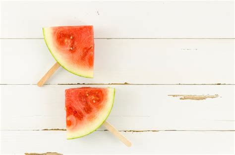 Free Photo | Two watermelon slice popsicles on table