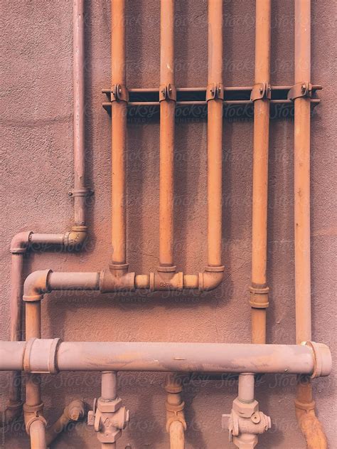 Close Up Of Brown Utility Pipes On Building Wall by Rialto Images | Water well drilling, Pipes ...