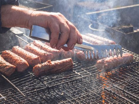 Premium Photo | Cooking bbq meat. romanian mititei and cooked on the grill in the smoke.