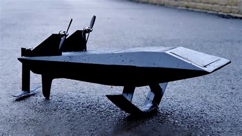 a toy airplane sitting on top of a wet ground next to a street with no ...