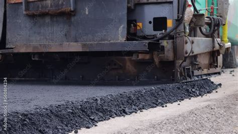 Repair and construction of the road, paver compresses the asphalt ...