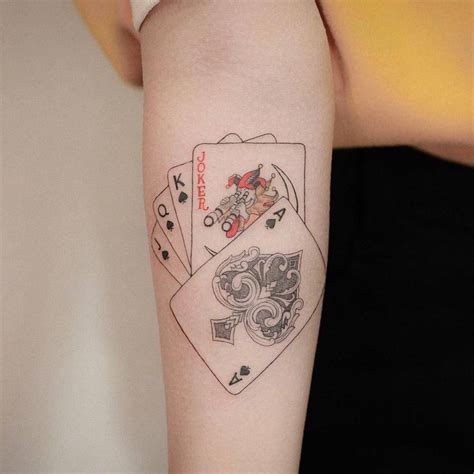 Playing cards tattoo on the inner forearm