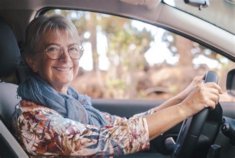 Premium Photo | Smiling senior woman driving her car