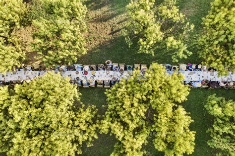 Overhead view of people having food at outdoor dining table[11100036396]の写真素材・イラスト素材｜アマナイメージズ