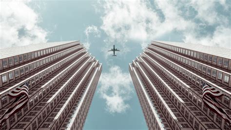 Worm's-eye view Photo of Plane Between Two High-rise Buildings · Free Stock Photo