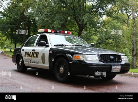 A police car with lights on, driving on a residential street in ...