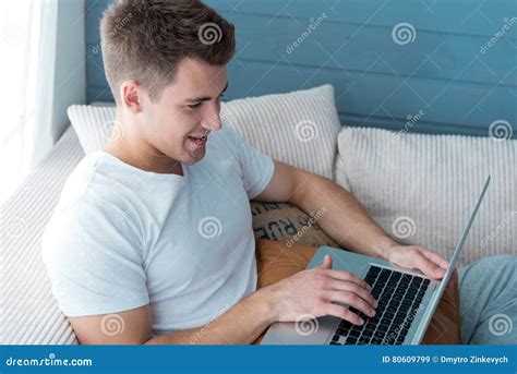 Cheerful Young Smiling Man Using Laptop. Stock Image - Image of furniture, emotions: 80609799