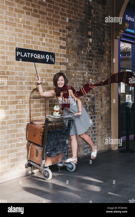 People taking photos by 9 3/4 platform inside King's Cross station ...