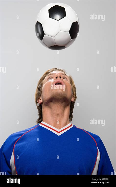 Footballer heading football Stock Photo - Alamy