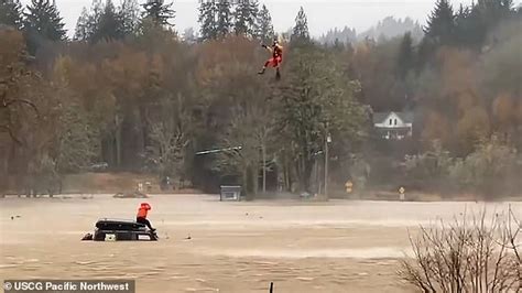 Incredible moment Washington state Coast Guard hangs below helicopter to save driver sitting on ...