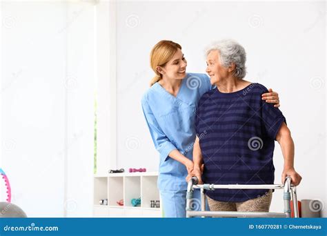 Caretaker Helping Elderly Woman with Walking Frame Stock Image - Image of physiotherapy, hoist ...