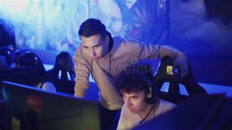 Pro Gamers Trainer Giving Advice To His Friend while he is Playing Round of Video Game in Modern ...