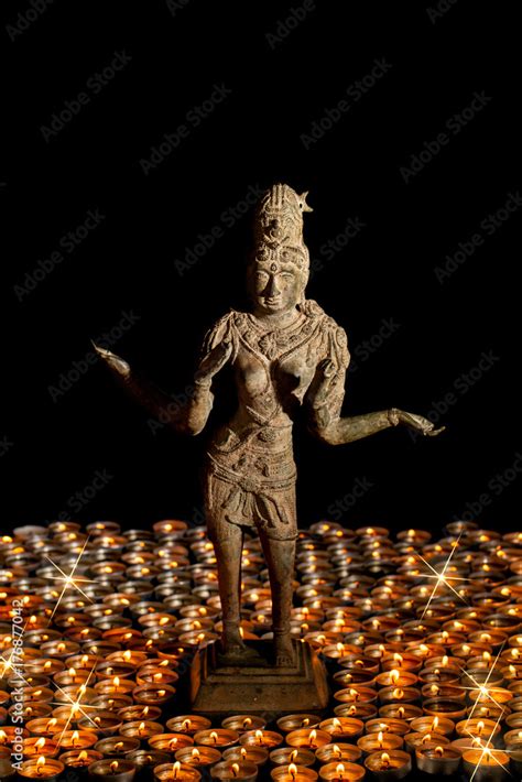 Diwali. Traditional bronze statue of Hindu Goddess Lakshmi or Laxmi in flaming candle light ...