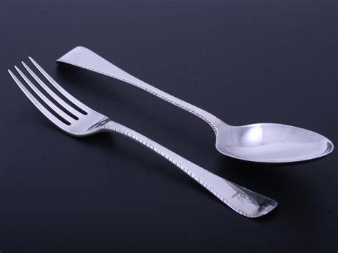 A George IV Old English feather edge sterling silver table fork and matching table spoon ...