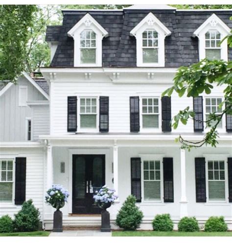 Cute simple cozy white house with black shutters, topiaries and sconces by the front door. Cute ...