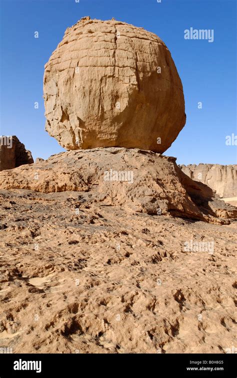 Eroded rock formation, round boulder balanced on a rock base in Tin Akachaker, Tassili du Hoggar ...