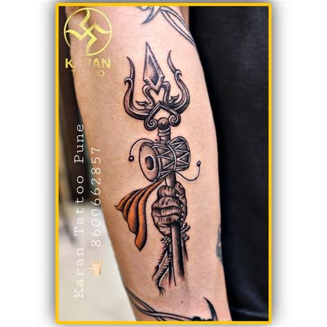 a person with a tattoo on their arm holding a knife and an arrow in his hand