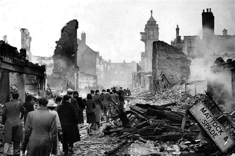 Commuters make their way through the rubble of Coventry following the Luftwaffe raid which took ...