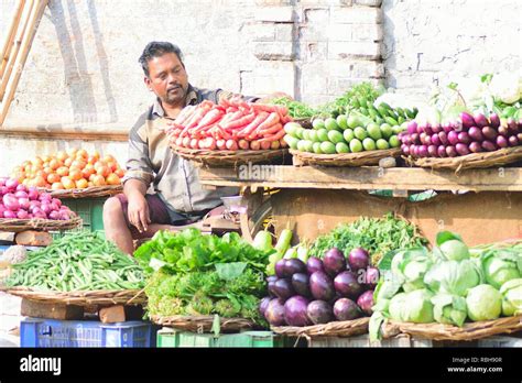 Indian vegetable seller at food market in Varanasi, India. Small vegetable & fruit vendors are ...