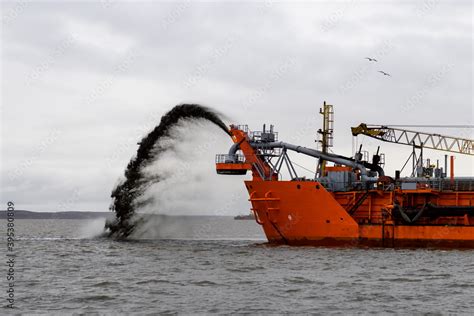 Vessel engaged in dredging. Dredger working at sea. Ship excavating material from a water ...