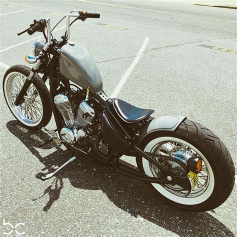 a black motorcycle parked in a parking lot next to a curb with no one on it