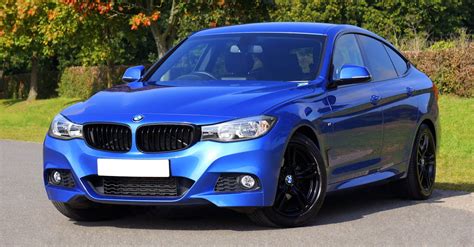 Blue Bmw Sedan Near Green Lawn Grass · Free Stock Photo