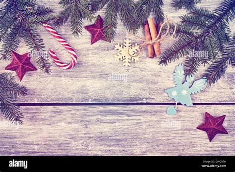 Vintage toned Christmas background, spruce branches with decorations on a rustic wooden table ...