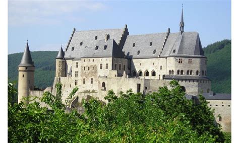 an old castle is surrounded by trees and hills