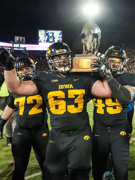 The Iowa Hawkeyes grasp the Floyd of Rosedale trophy # ...